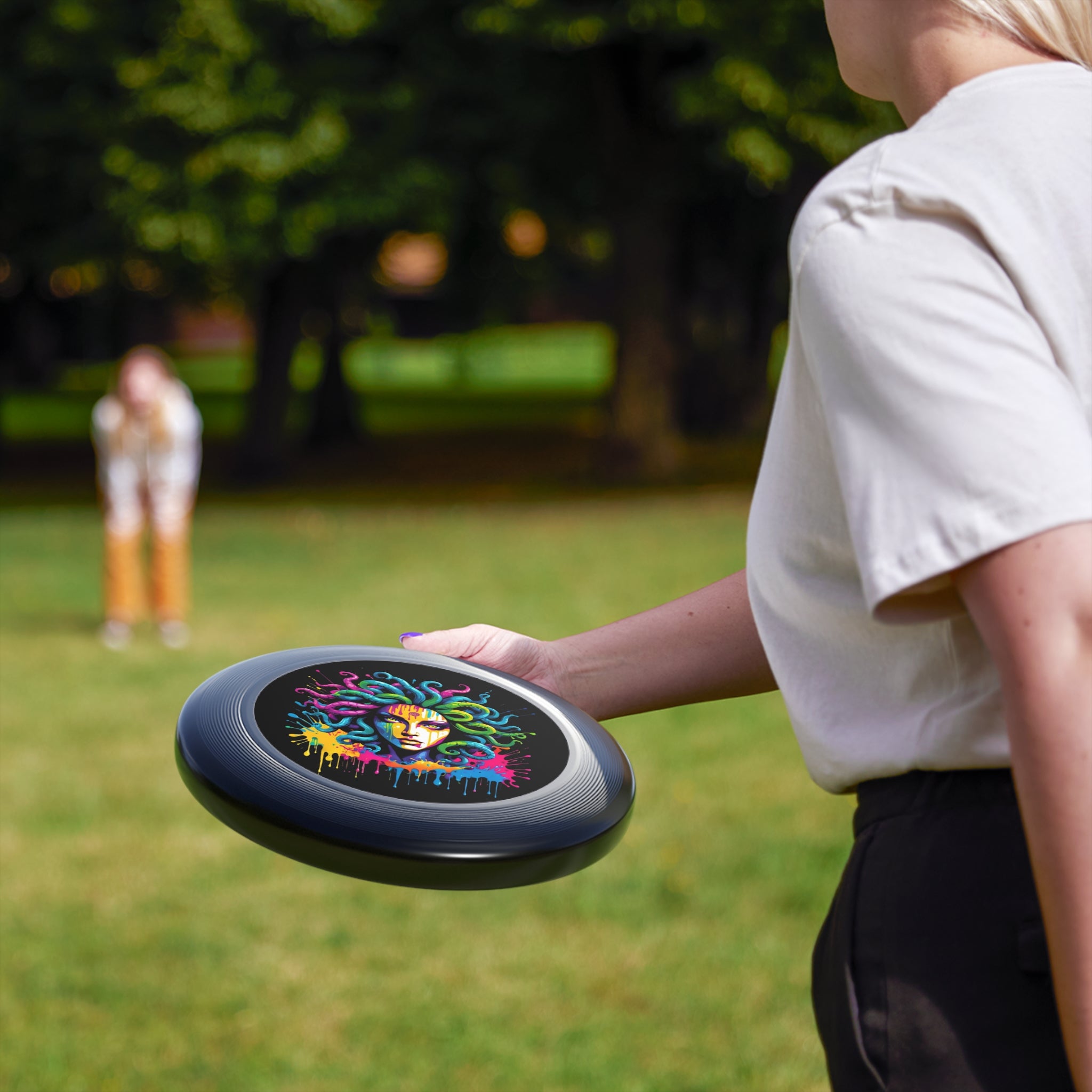 Colorful Medusa flying disc held outdoors, showcasing its vibrant graffiti-inspired design. Perfect for outdoor fun.