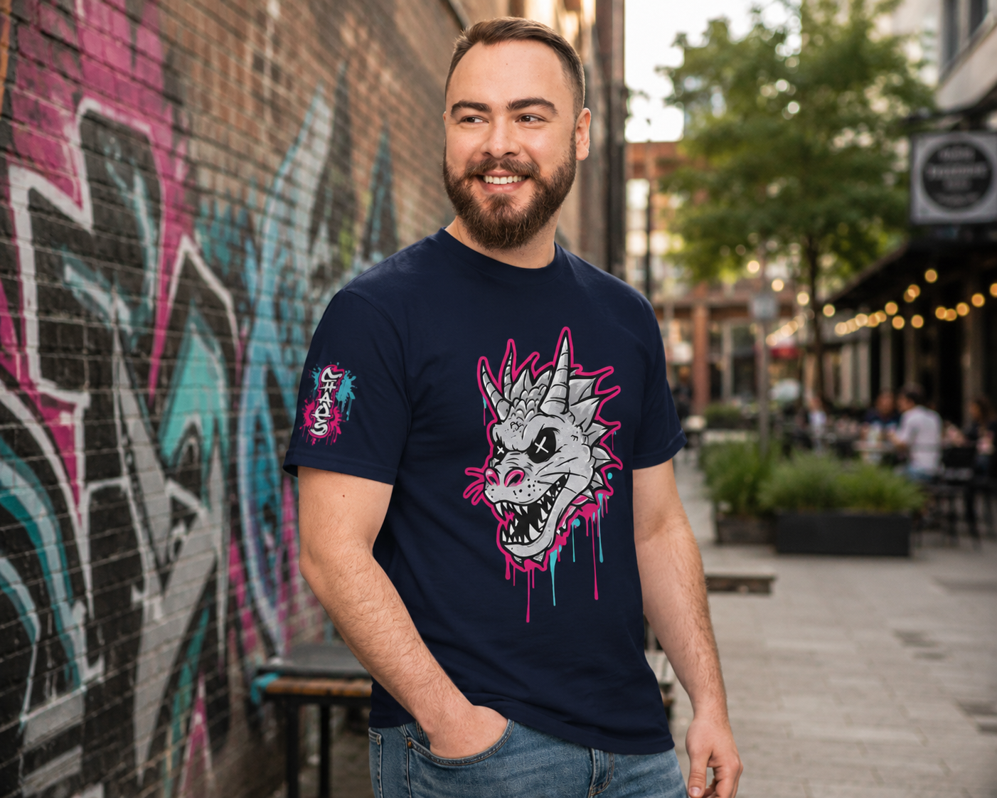 Navy blue t-shirt featuring a bold dragon skull graphic with electric pink and cyan paint drips, worn in an urban setting.