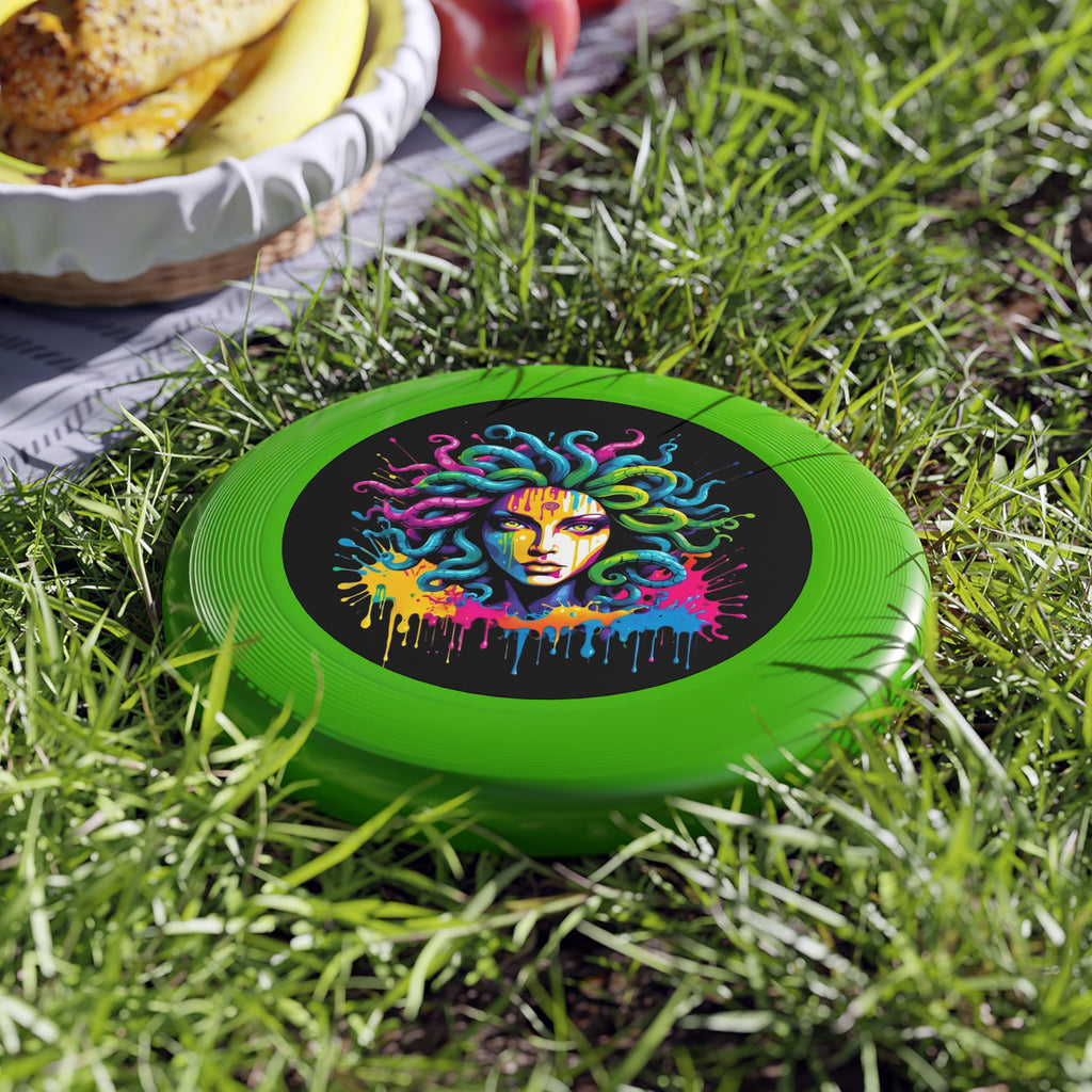 Vibrant green Medusa flying disc on grass with a picnic setting and bowl of fruit in the background.
