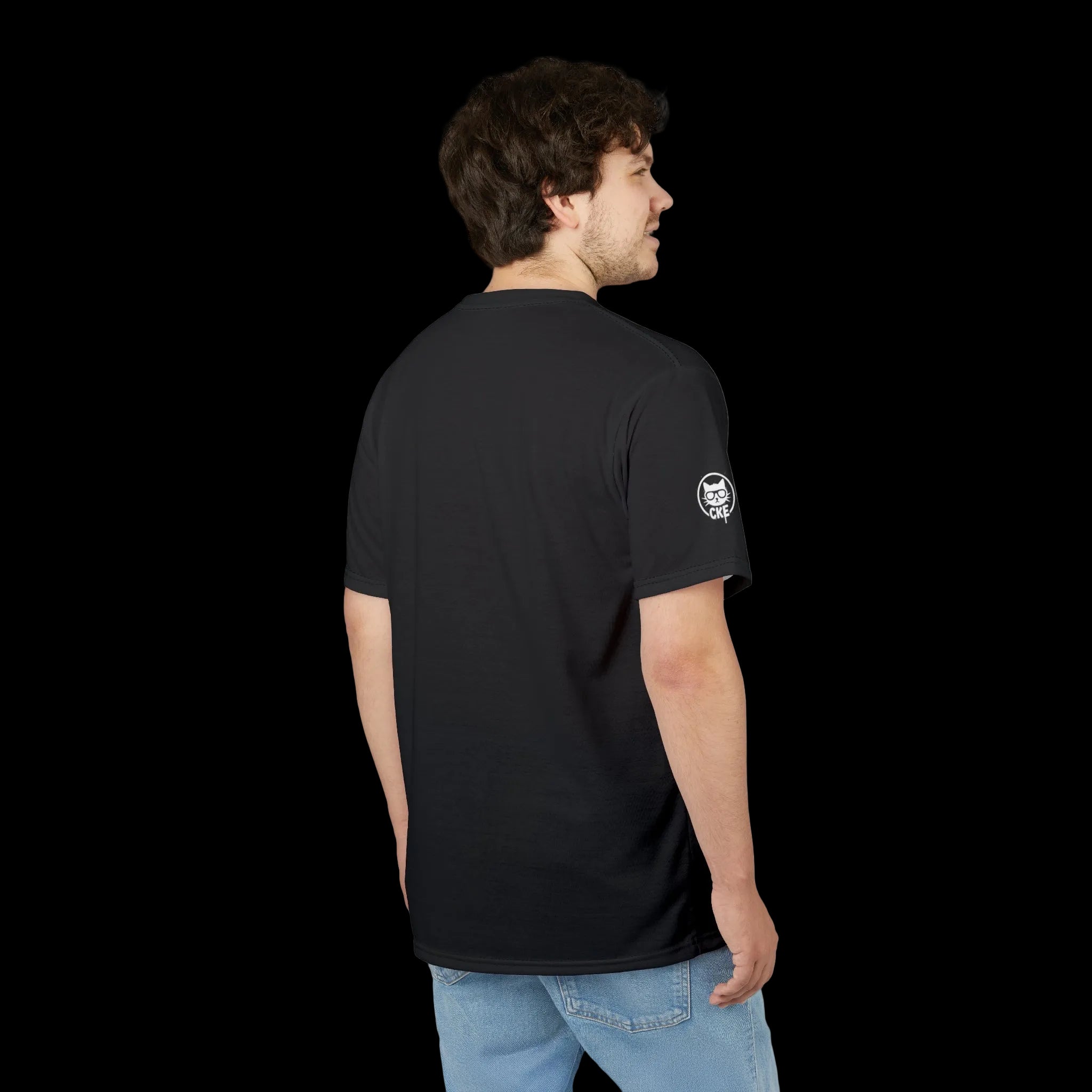 A back-view lifestyle mockup of a person wearing a black t-shirt with a white Chaos Kitten Emporium (CKE) cat logo on the sleeve.
